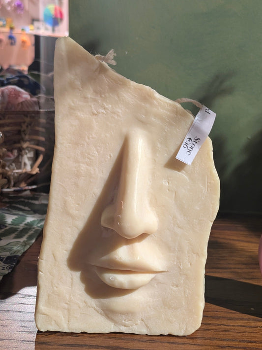 VitaUnlimited Stone Face Candle with carved stone face design, perfect for decorative and ambient lighting in home decor.